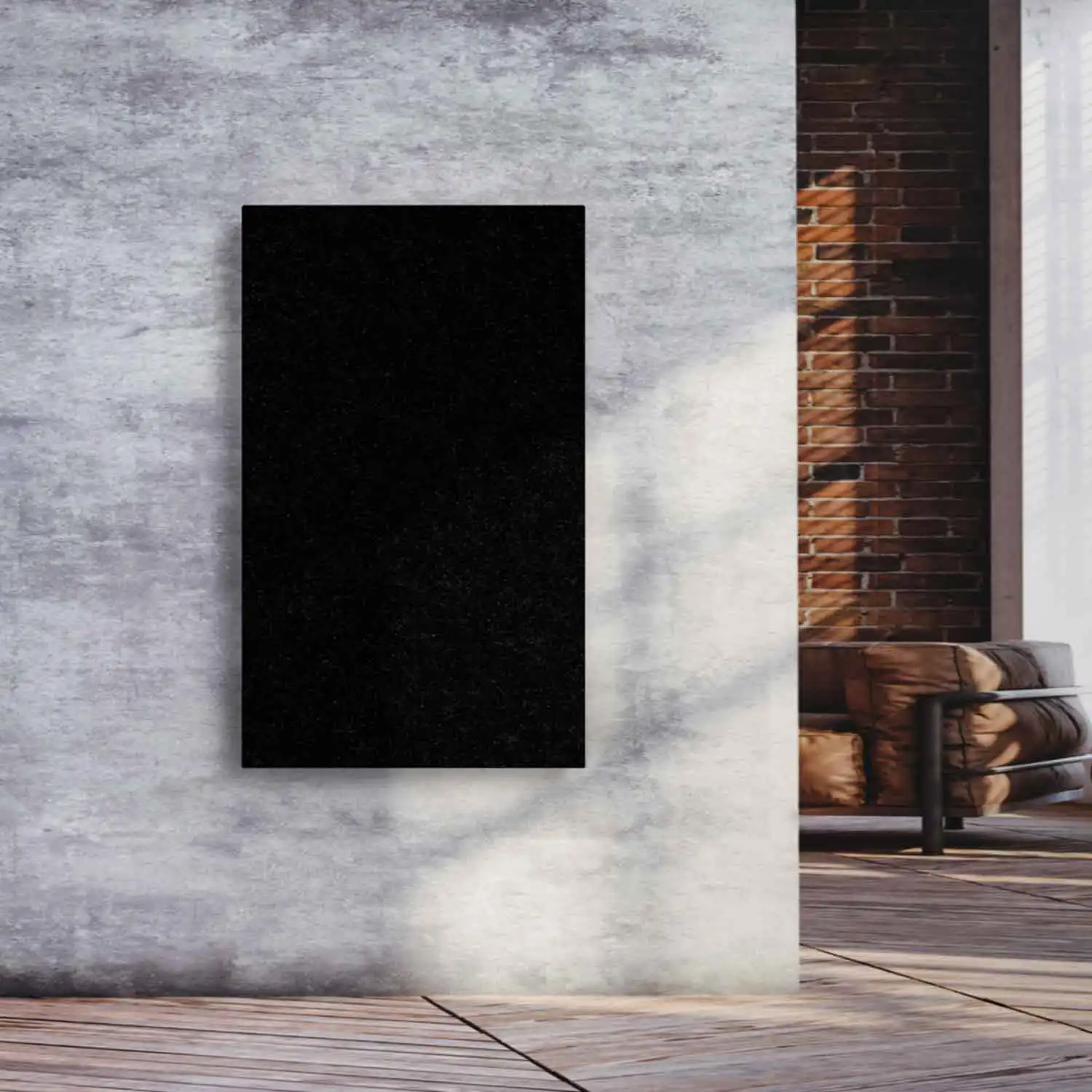 Designradiator Nero Assoluto in zwarte graniet aan een betonnen wand in een woonruimte