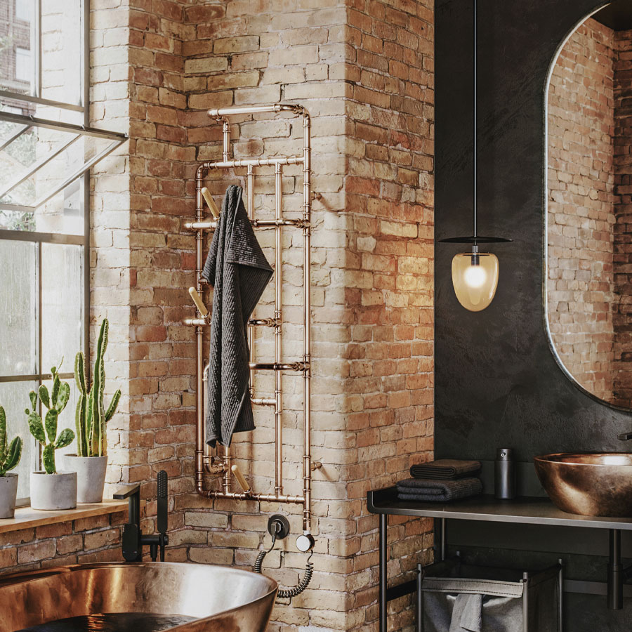 Designradiator Pająk, in een badkamer met bakstenen muur