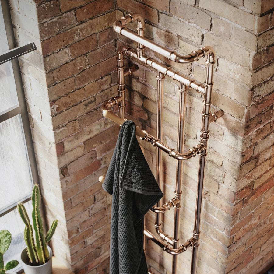 Designradiator Pająk, in een interieur met bakstenen muur en handdoek