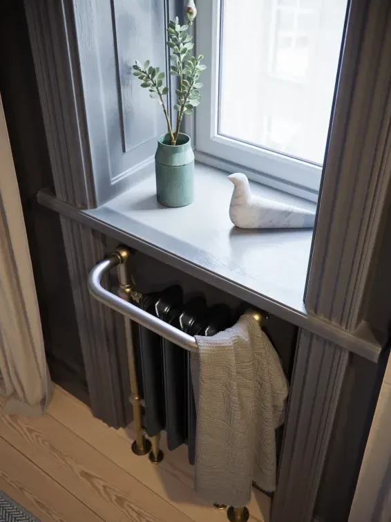 Detail van de Plain Towel Rail in zwart met een geborsteld messingkleurig frame